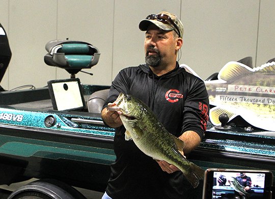 The Sentinel-Record/Richard Rasmussen PRIZED CATCH: Fisherman Pete Clark holds up "Big Al," the largemouth bass prized at $15,000 in Visit Hot Springs' 2017 Hot Springs Fishing Challenge, at the Hot Springs Convention Center on Thursday.