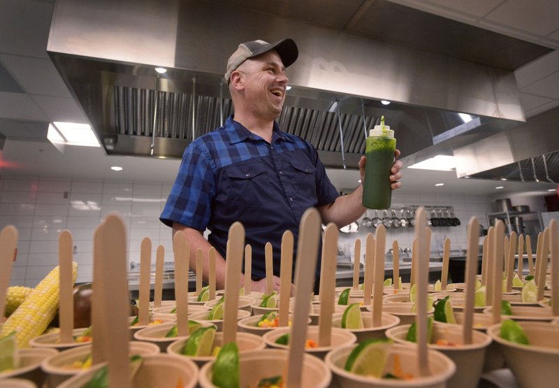 NWA Democrat-Gazette/BEN GOFF @NWABENGOFF
Luke Wetzel chef at Oven & Tap in Bentonville, finishes off samples of a sweet corn recipe with a cilantro and basil sauce Thursday during the first night of the Bite NW Arkansas food festival at 8th Street Market in Bentonville. The event, part of the festivities surrounding the Walmart NW Championship presented by P&G, continues today with more samples and cooking demonstrations from Northwest Arkansas restaurants and businesses.
