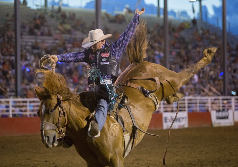 Jacobs Crawley of Boerne, Texas, competes in the saddle bronc Thursday during the Rodeo of the Ozarks at Parsons Stadium in Springdale. Crawley scored 87 on the ride.