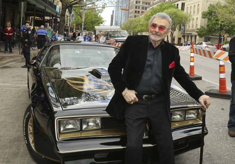 FILE - In this March 12, 2016 file photo, Burt Reynolds sits on a 1977 Pontiac Trans-Am at the world premiere of "The Bandit" at the Paramount Theatre during the South by Southwest Film Festival in Austin, Texas. Hundreds of fans in Trans Ams made it to Atlanta to celebrate the 40th anniversary of "Smokey and the Bandit." About 350 cars retraced actor Burt Reynolds' wild ride from the Texas-Arkansas line to Atlanta in the movie that roared into pop culture in 1977. (Photo by Jack Plunkett/Invision/AP)
