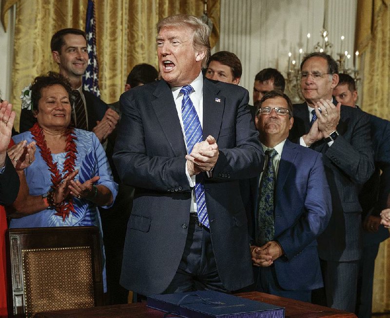 President Donald Trump applauds Friday at the White House after signing the Department of Veterans Affairs Accountability and Whistleblower Protection Act of 2017. Arkansas Sens. Tom Cotton (back left) and John Boozman (applauding right) co-sponsored the legislation.