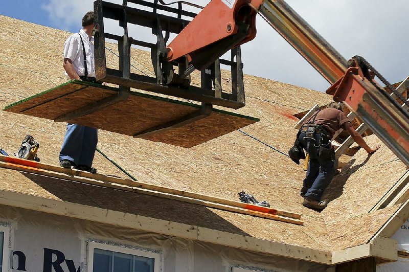 Builders work on the roof of a new house in Jackson Township, Butler County, Pa., on June 1. Sales new single-family homes rose last month, the government said Friday. 