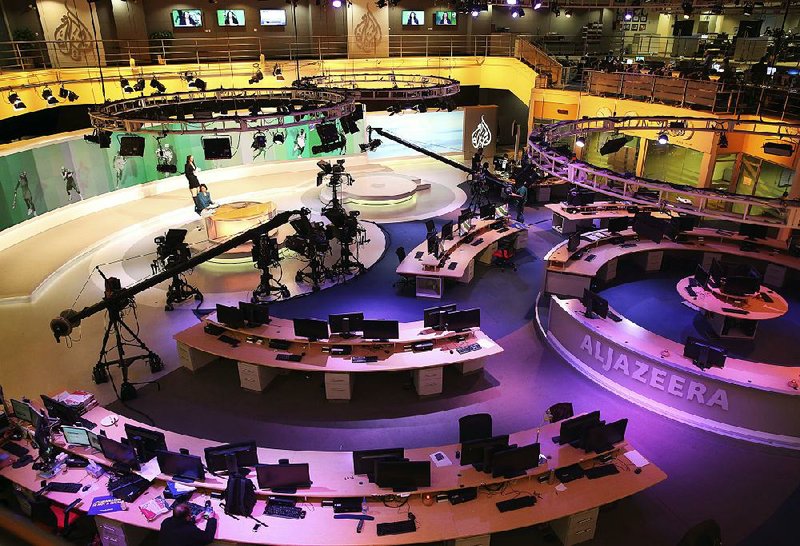 Staff members of Al-Jazeera International work at the news studio in Doha, Qatar, in January 2015.