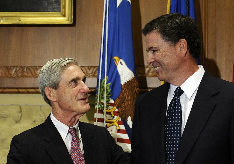 Then-incoming FBI Director James Comey (right) talks with outgoing FBI Director Robert Mueller before Comey was sworn in at the Justice Department on Sept. 4, 2013.