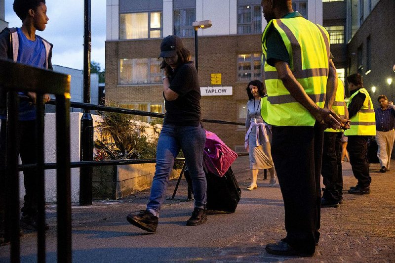 Residents move out of the Taplow residential tower block Friday in the London borough of Camden after fire officials said they could not guarantee that the building is safe. 