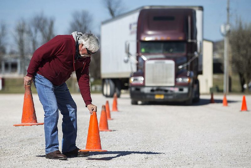 Doug Carter, founder of Mid America Truck Driving School, lines up pylons for driver training.