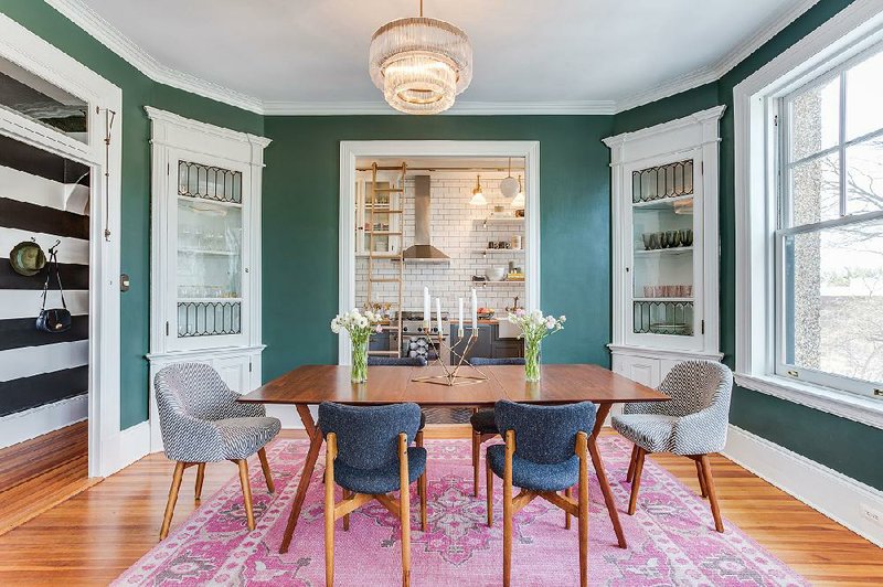 The dining room in Louisa Bargeron’s apartment in Washington retains two original corner cabinets with leaded glass. The walls are a warm green.