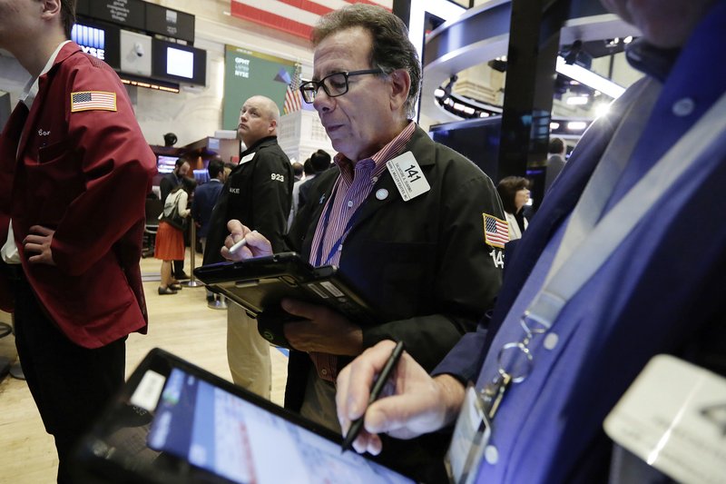 Trader Sal Suarino, center, works on the floor of the New York Stock Exchange, Friday, June 23, 2017. U.S. stock indexes inched higher Friday as energy companies clawed back some of their sharp losses from earlier in the week. (AP Photo/Richard Drew)