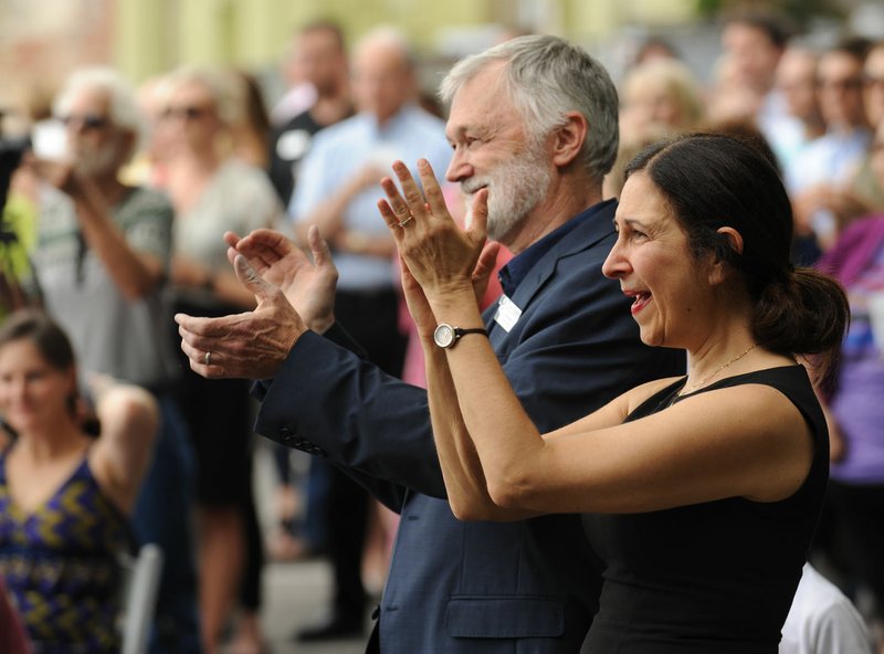 Robert Ford (center), artistic director for TheatreSquared, and Amy Herzberg, associate artistic director, applaud Friday during a groundbreaking for TheatreSquared’s planned 50,000-square-foot facility at 477 W. Spring St. in Fayetteville. The group announced it had collected $21 million of a $34 million goal for the project.