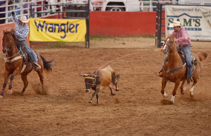 NWA Democrat-Gazette/BEN GOFF @NWABENGOFF Cody Heflin (left) and Thompson Berryhill take their turn in the team roping event Friday during the third night of the 73rd annual Rodeo of the Ozarks at Parsons Stadium in Springdale. Heflin and Berryhill were the only team of the night to get a clean rope, with a time of 8.0 seconds. 