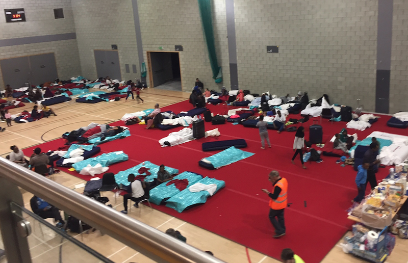 People gather in a leisure centre in Swiss Cottage, north London, Saturday June 24, 2017, after the local council evacuated some 650 homes overnight. Camden Borough Council said in a statement Saturday that it housed many of the residents at two temporary shelters while many others were provided hotel rooms, after inspectors found fire safety issues in housing towers, following the inferno in a west London apartment block that killed 79. 