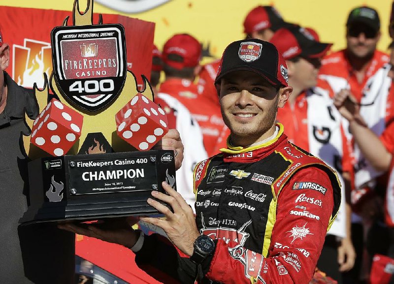 Kyle Larson holds the FireKeepers Casino 400 trophy after winning a NASCAR Sprint Cup series auto race, Sunday, June 18, 2017, in Brooklyn, Mich. 