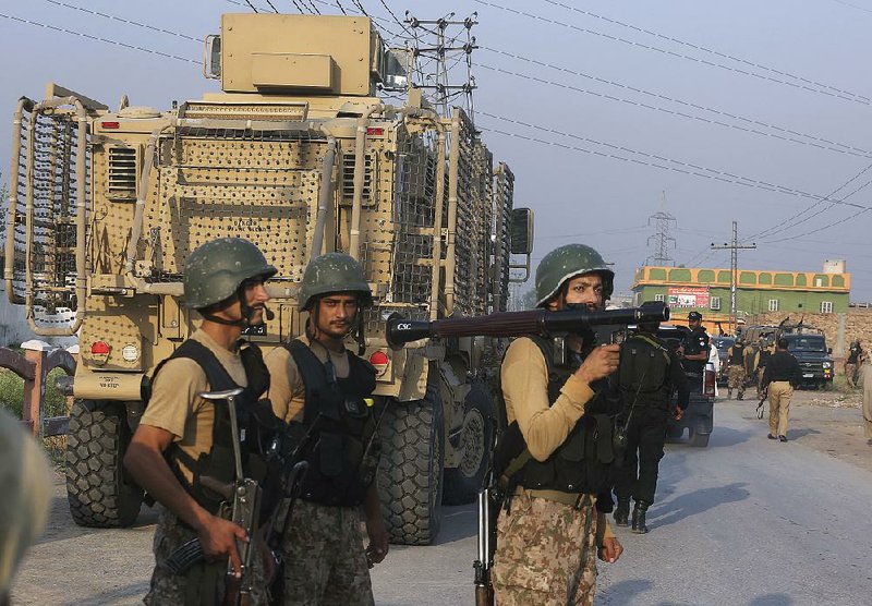 Pakistani troops leave after a shootout with militants Saturday on the outskirts of Peshawar, Pakistan.