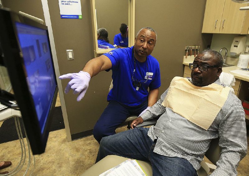 Dr. Darryl Ragland (left) talks with patient and veteran Bernard Brown on Saturday at the Aspen Dental location in Little Rock. Aspen Dental provided free care for veterans Saturday. 