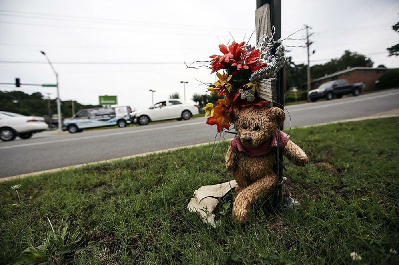 A memorial to Samantha Olson sits Saturday at the intersection of McCain and JFK boulevards in North Little Rock, where she was shot and killed on Aug. 14, 2013.