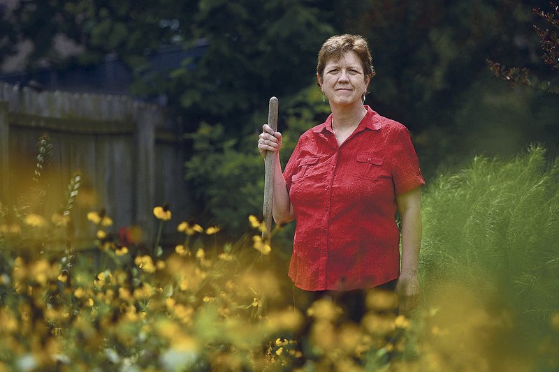 Dana Collins poses for a photo Saturday in the flower garden at her home in Fayetteville. Collins has used Medicaid coverage for about a year to help treat chronic heart failure that has required surgery and a pacemaker. The insurance covers her cardiologist and nurse visits, along with help for severe sleep apnea and other health concerns, said the 58-year-old.