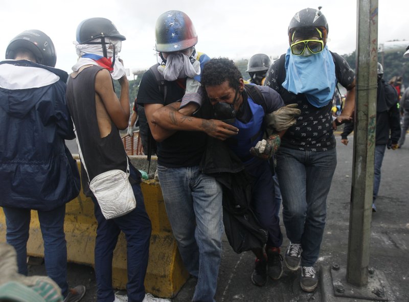 A demonstrator is carried away by others after being injured during protests in Caracas, Venezuela, Saturday, June 24, 2017. Demonstrators took to the streets asking restraint from security forces after more than 70 people have been killed during almost 90 days of protests seeking President Nicolas Maduro's removal. (AP Photo/Ariana Cubillos)