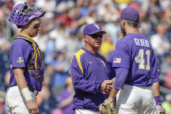 LSU pitcher Caleb Gilbert, right, receives a handshake from coach Paul Mainieri, center, with catcher Michael Papierski (2) watching after holding No. 1 national seed Oregon State to two hits in 7 1/3 innings in an NCAA College World Series baseball elimination game in Omaha, Neb., Saturday, June 24, 2017. (AP Photo/Nati Harnik)