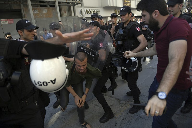 Riot police move to detain a person as they stop protesters for lesbian, gay, bisexual, trans and intersex rights from gathering in large numbers for LGBT Pride protest following a ban issued by the governor, in Istanbul, Sunday, June 25, 2017. The Istanbul governor's office on Saturday banned the LGBT event, for the third year in a row, citing reasons of safety and public order.