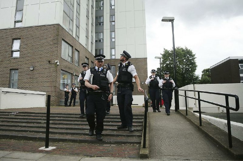 Police officers patrol outside Dorney Tower, part of the Chalcots Estate in the borough of Camden, north London, on Sunday.