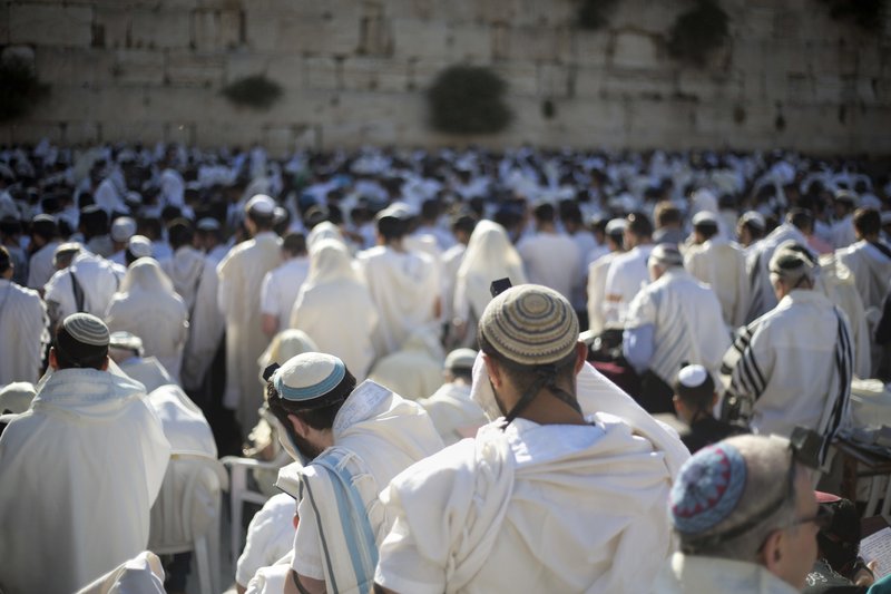 In this May 24, 2017 file photo, Jewish men pray at the Western Wall, the holiest place where Jews can pray, in Jerusalem's Old City, during Jerusalem Day celebrations. 