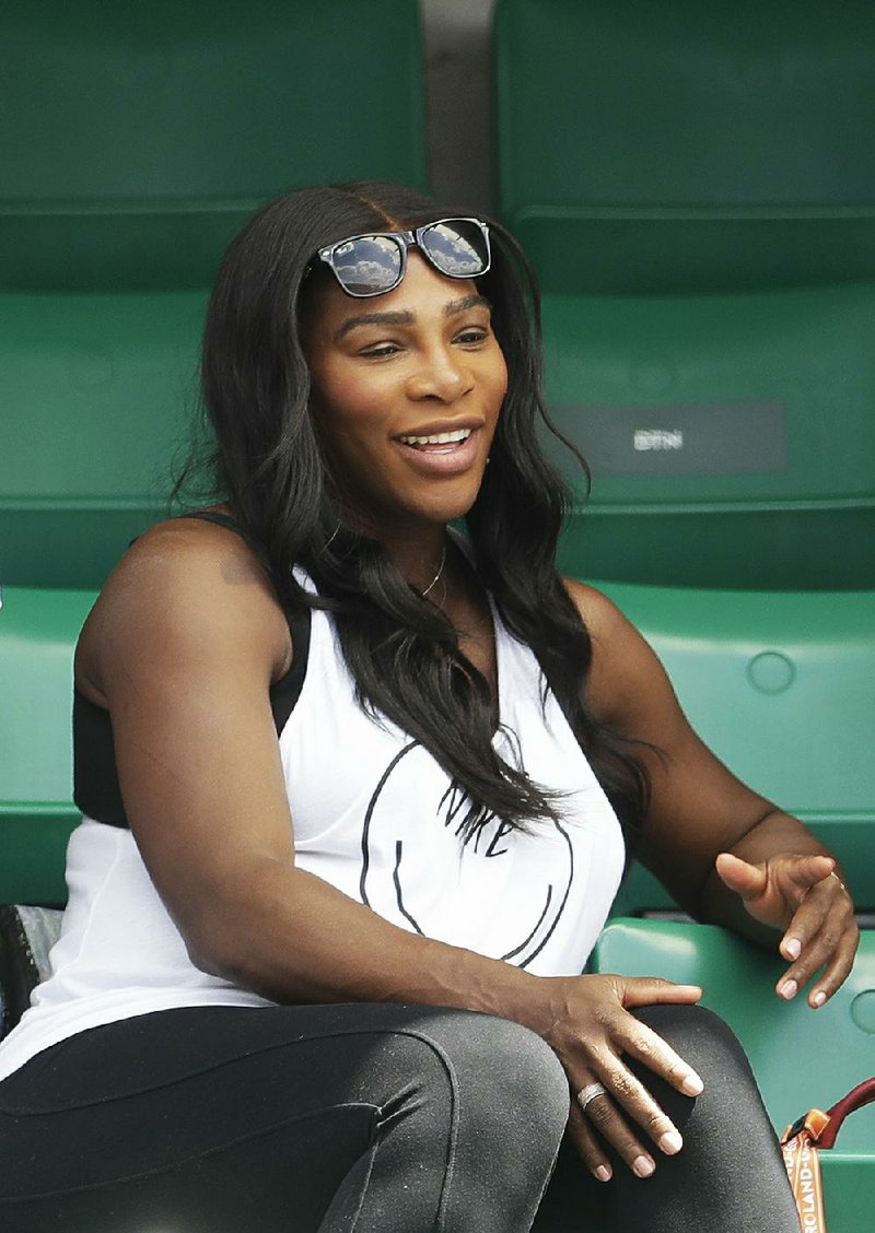 Serena Williams of the U.S., center, watches her sister Venus Williams' match against Japan's Kurumi Nara during their second round match of the French Open tennis tournament at the Roland Garros stadium, in Paris, France. Wednesday, May 31, 2017. 