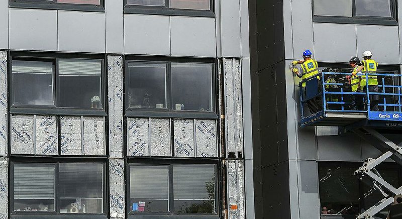 Workers in Britain remove cladding from the Whitebeam Court residential high-rise in Pendleton, Greater Manchester, on Monday.