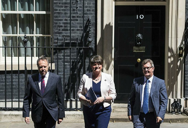 Democratic Unionist Party leader Arlene Foster, flanked by deputy leader Nigel Dodds (left) and party Parliament member Jeffrey Donaldson, arrives to make a statement to the media outside 10 Downing St. in central London on Monday after their meeting with Britain’s Prime Minister Theresa May.