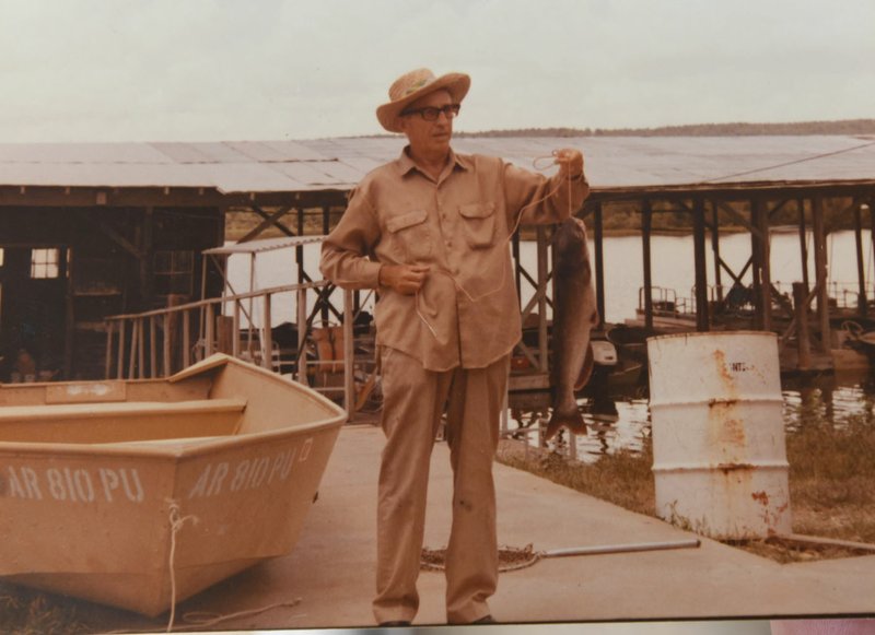 The late Dr. Ross Bizzell, father of fish-story champion Joy Long of Fayetteville, shows a catfish he caught.