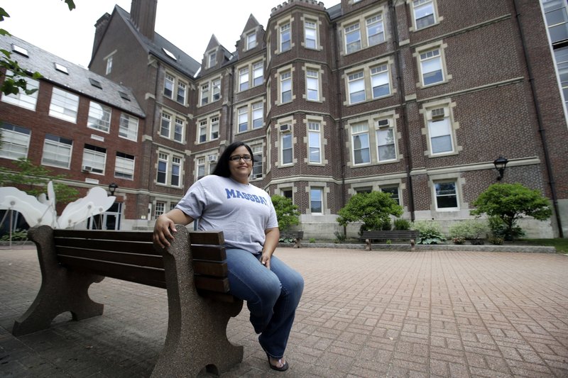 In this June 16, 2017, photo, Danielle Ramos, 30, poses at MassBay Community College in Wellesley, Mass., where she pursued her education after being defrauded by a for-profit college. Thousands of students who were defrauded by for-profit colleges were told by the Obama administration that their student loans would be forgiven, but the Trump administration has yet to keep that promise. 