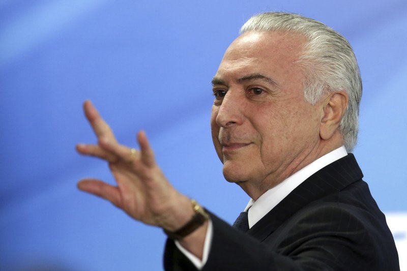 Brazil's President Michel Temer waves as he exits after attending a ceremony at the Planalto Presidential Palace, in Brasilia, Monday, June 26, 2017. 