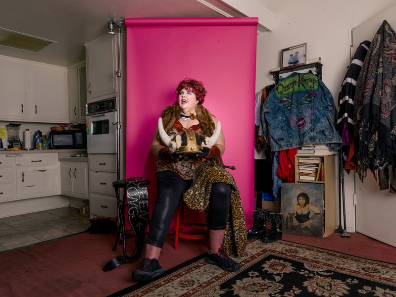 Dee Booher, aka Matilda the Hun or Queen Kong, poses in her home in Seal Beach, Calif., dressed in her old costume from GLOW.