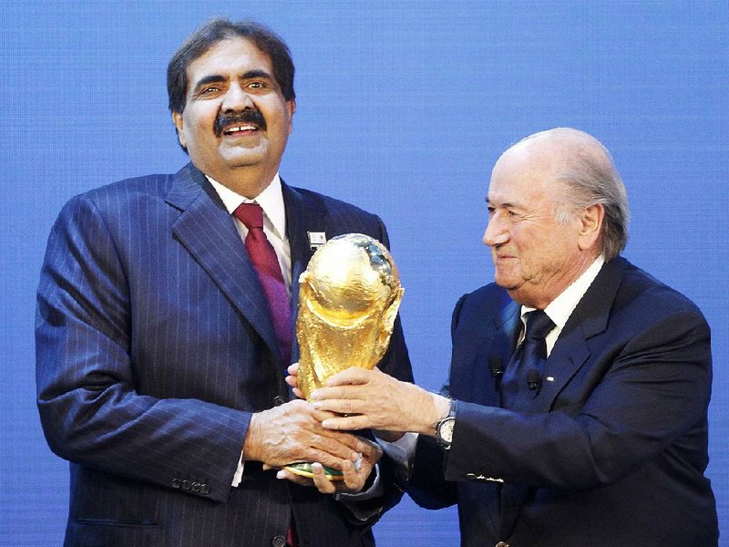 Sheikh Hamad bin Khalifa Al-Thani, Emir of Qatar, (left) receives the World Cup trophy from former FIFA President Joseph Blatter after finding out that Qatar would host the 2022 World Cup in this Dec. 2, 2010, file photo. A report from former FIFA chief ethics investigator Michael Garcia was released Tuesday, detailing the results of a months-long inquiry surrounding possible corruption and voting violations that awarded the 2018 and 2022 World Cup tournaments on the same day.