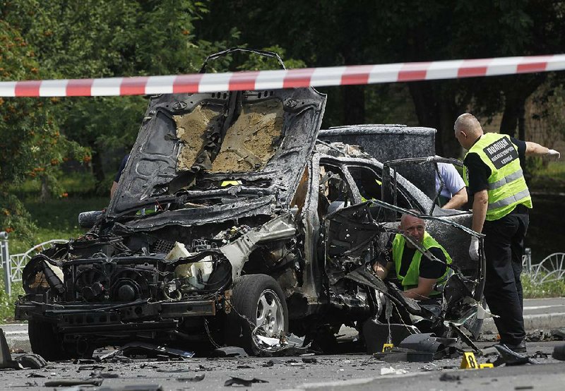 Forensic experts examine the wreckage of a car after a bombing Tuesday in Kiev, Ukraine.