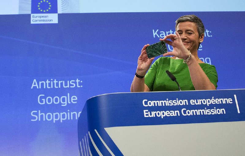 European Union Commissioner for Competition Margrethe Vestager takes a photo with her cellphone during a news conference at EU headquarters in Brussels on Tuesday. Vestager announced that Google had been fined for steering users toward its comparison shopping site. 
