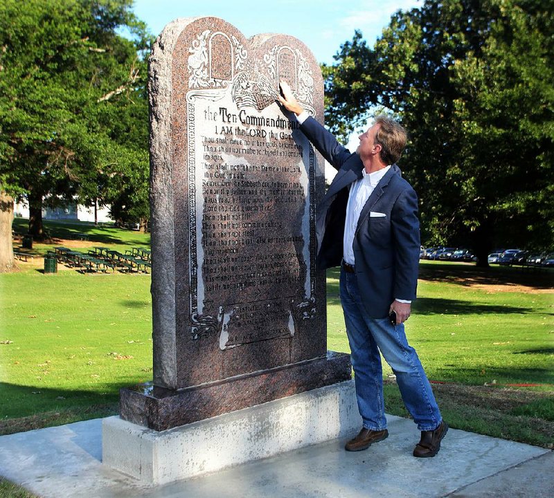 Scott Stewart, a senior pastor at the Agape Church in west Little Rock, checks out the Ten Commandments monument Tuesday on the state Capitol grounds. The design was taken from the tablet in Cecil B. DeMille’s 1956 film of the same name.