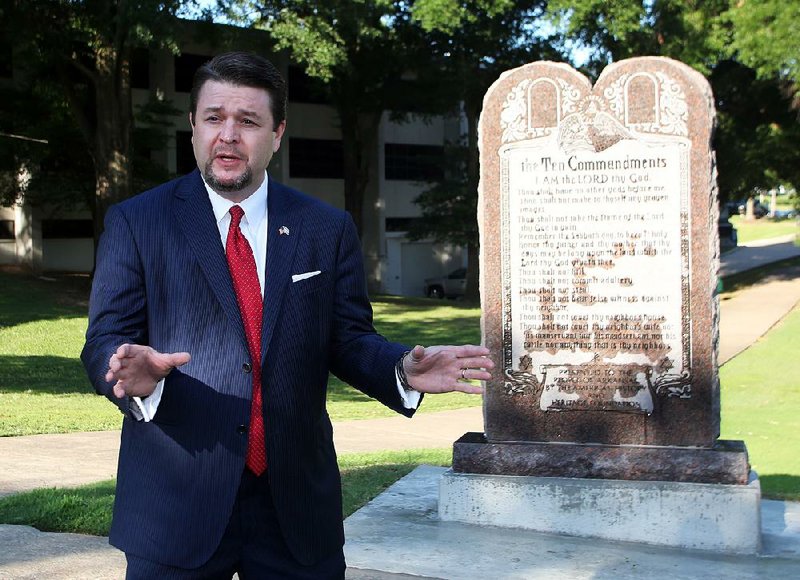 FILE — State Sen. Jason Rapert, R-Bigelow, who sponsored the legislation that led to installation of the Ten Commandments monument on the state Capitol grounds, speaks in front of it on June 27. That monument was destroyed hours later, but Rapert says a new version has been completed and is ready to be installed.
