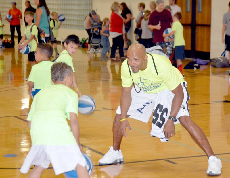 Michael Burchfiel/Herald-Leader Hinsey, or as he is known to kids, Coach Sim, helped lead a basketball camp at John Brown University in June.