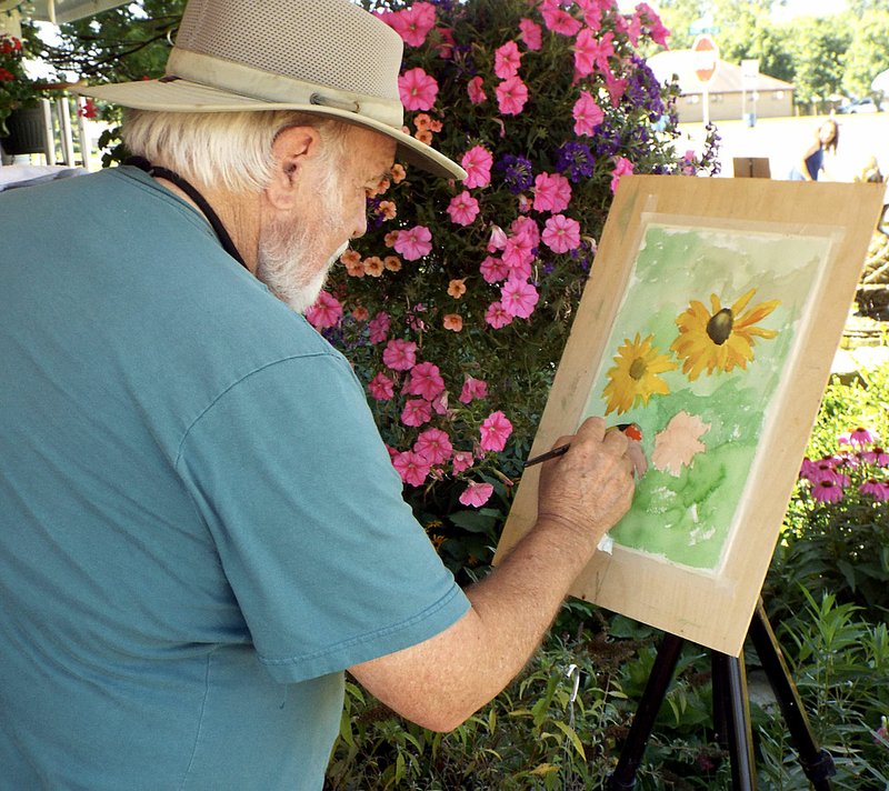 Photo by Randy Moll John Dillingham of Prairie Grove worked on a painting of the flowers at The Garden Gate flower shop in Gentry. He is a part of Plein Air Painters of the Ozarks and visited the Gentry flower shop on June 21 to paint some of the many flowers on display in the garden there.