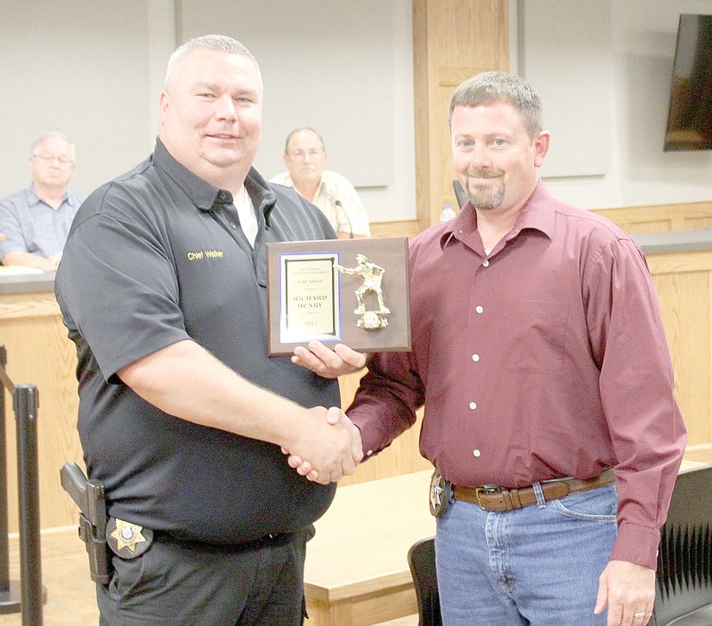 Keith Bryant/The Times of Northeast Benton County
Police chief Ryan Walker, left, hands the first-ever Top Shot award to officer Richard Henry, who scored a 493 out of a possible 500 in his firearm qualification.