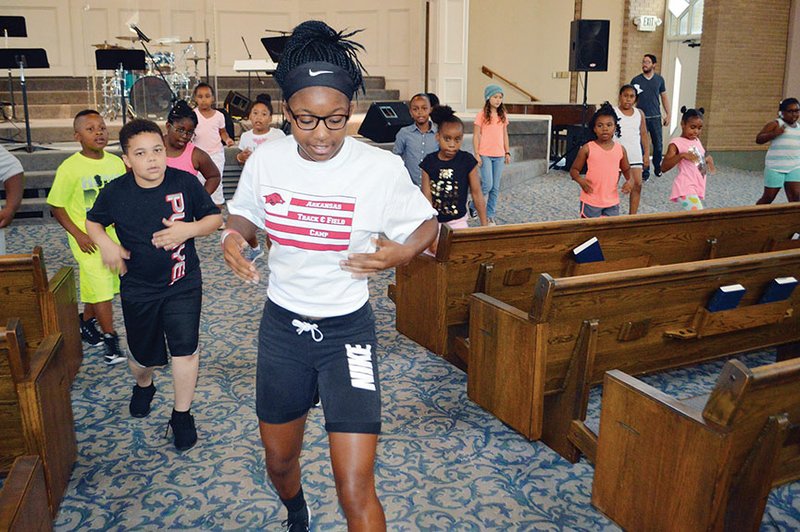 Dance instructor Taylor Conway, 16, leads choreography Wednesday in a MixxedFit class for Summer Impact Camp participants at The Ministry Center in Conway. The camp, sponsored by Choosing to Excel, includes art, dance, reading, field trips and more. Students pictured include, front left, Kayleb Kern, 9, of Jackson, Miss.