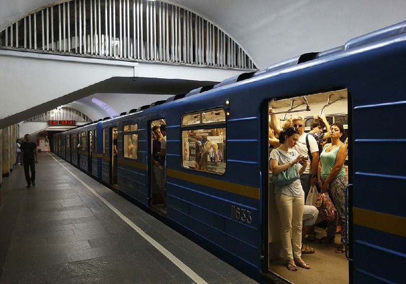 Passengers use mobile phones a subway Wednesday in Kiev, Ukraine. A computer virus attack affected the subway system.
