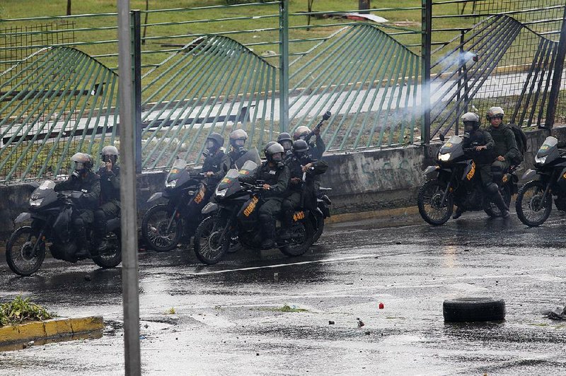 Security forces fire tear gas at anti-government protesters Wednesday in Caracas, Venezuela.