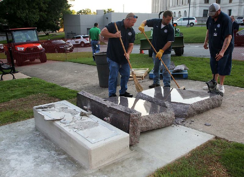 Secretary of state workers start cleanup Wednesday around the smashed Ten Commandments monument that was just installed on Tuesday.