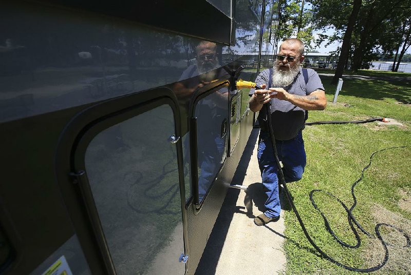 Gary Richmond of Vilonia works Wednesday afternoon setting up his travel trailer for a stay at Maumelle Park in Little Rock. Richmond was staying at the park with his wife, Barbara, and their dog Moxie. 