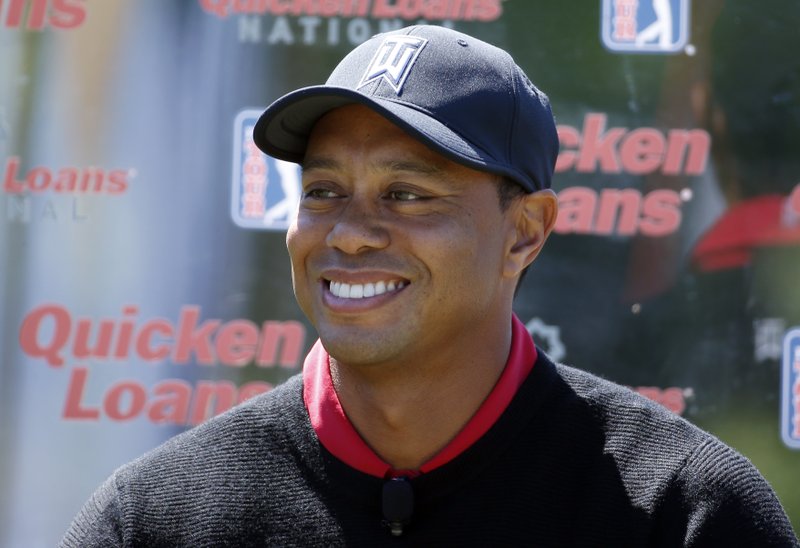 FILE - In this May 16, 2016, file photo, Tiger Woods pauses during a Quicken Loans National golf tournament media availability on the 10th tee at Congressional Country Club, in Bethesda, Md. Tiger Woods' absence from golf isn't just being felt on the course. The Quicken Loans National, which he usually hosts but will be without him this year as he's being treated at a clinic for his use of prescription drugs, is doing its best to press on without him, but the buzz around the event has faded. (AP Photo/Alex Brandon, File)