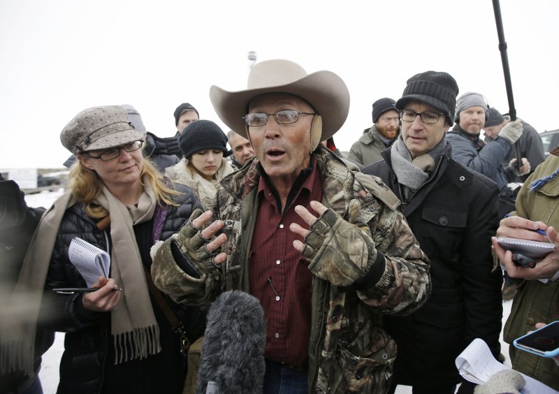 FILE - In this Jan. 5, 2016 file photo, Robert "LaVoy" Finicum, center, a rancher from Arizona, talks to reporters at the Malheur National Wildlife Refuge near Burns, Ore. (AP Photo/Rick Bowmer, File)