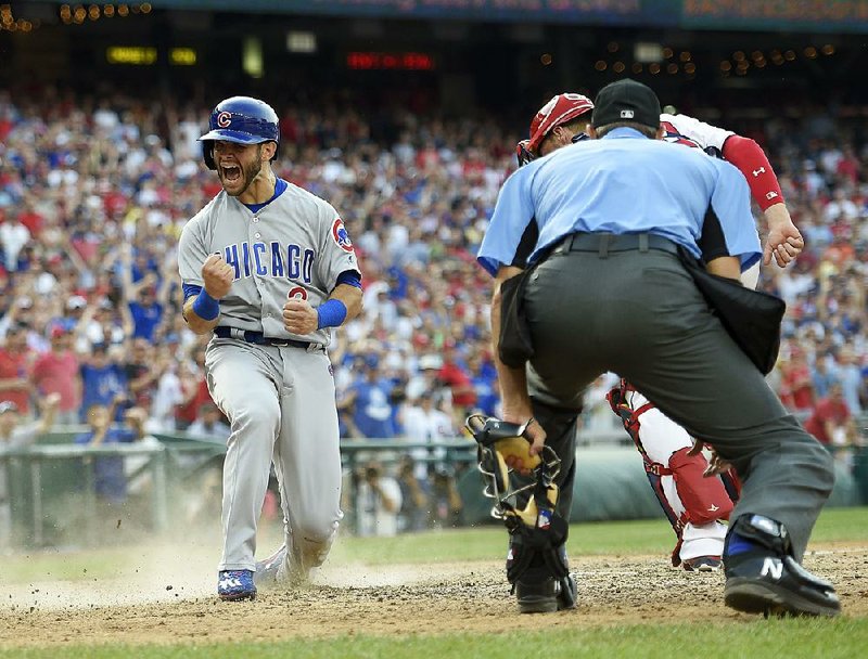 Chicago Cubs base runner Tommy La Stella reacts after scoring on a hit by Jon Jay during the ninth inning of Thursday’s game against Washington. The Cubs scored three runs in the inning to erase a two-run deficit to beat the Nationals 5-4.