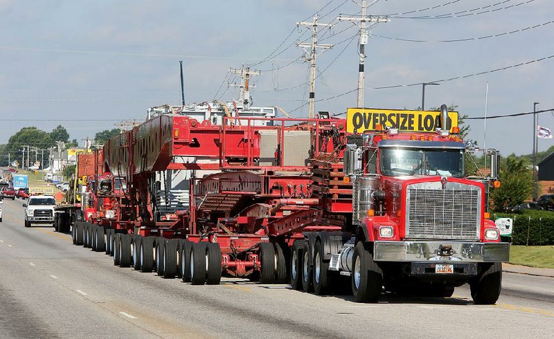 Southwestern Electric Power Co. contractors transport a 454,000-pound autotransformer Thursday near the intersection of U.S. 412 and Arkansas 112 in Tontitown. The caravan, which is more than 300 feet long and 19 feet wide, is scheduled to complete its journey today.