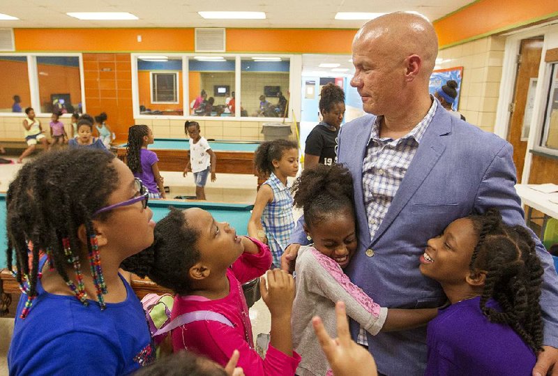 North Little Rock police officer Tommy Norman is swarmed by kids Thursday during his daily visit to the Wetherington Boys & Girls Club in North Little Rock. Norman, who has over 1 million people following his community policing videos on Instagram, usually posts social media video of the kids during his visits but was told by the city that he could no longer post on social media while on duty without approval.